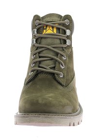 Bottine en cuir vert avec un bout rond, un laçage sur le devant et une semelle en caoutchouc grise. Présente des œillets gris et un logo jaune sur la languette.