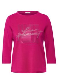 Chemise à manches longues fuchsia en tissu doux. Présente un imprimé graphique avec des motifs linéaires et des accents brillants. Encolure ronde, coupe décontractée.