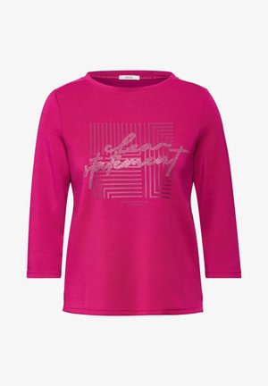 Różowa, długorękawowa koszula wykonana z miękkiego materiału. Posiada graficzny nadruk z liniowymi wzorami i błyszczącymi akcentami. Okrągły dekolt, luźny krój.