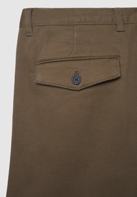 Braune Hose mit einer Gesäßtasche und Knopfverschluss, gefertigt aus strukturiertem Stoff mit einem dezenten diagonalen Muster.