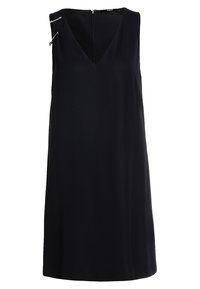 Musta hihaton mekko, jossa on V-pääntie, sileä pinta ja sivulla koristeena hakaneulat. Yksinkertainen, suora siluetti ja vetoketju takana.