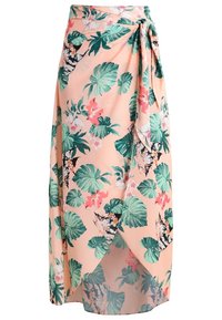 Růžová zavinovací sukně s vzorem zelených tropických listů a růžových květů, uvázaná uzlem v pase, se značně asymetrickým lemem.
