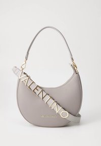 Grå läderhandväska med rundad form, med guldfärgade bokstäver "VALENTINO" och en justerbar axelrem.