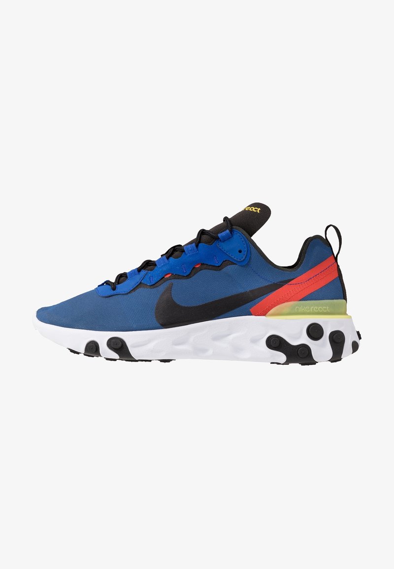 Nike React-skor med en blå textiloversida, svart Nike-logotyp, röda och gula detaljer, vit sula med texturerade svarta gummikuddar.