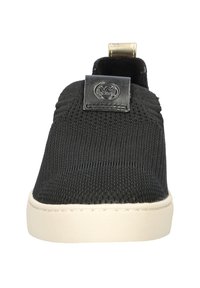 Scarpa nera slip-on con upper in tessuto testurizzato, caratterizzata da una toppa in pelle sulla linguetta. Suola in gomma off-white con una finitura liscia.