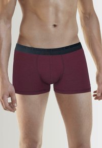 Bordowe bokserki wykonane z miękkiego materiału z czarnym elastycznym paskiem z logo "MR MARILYN". Wysokość średnia z dopasowanym krojem nogawki.
