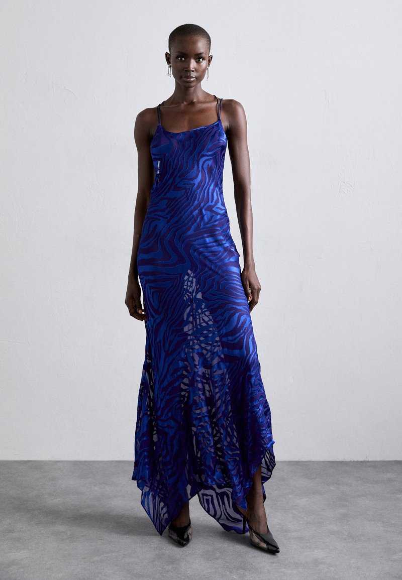 Blue and purple animal print maxi dress with thin straps, a fitted bodice, flared hem, and sheer overlay detailing.