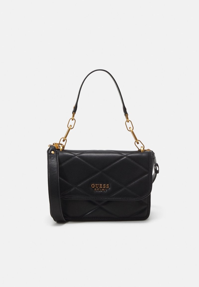 Sac à bandoulière en cuir noir matelassé avec des maillons de chaîne dorés et le logo GUESS sur le rabat avant.