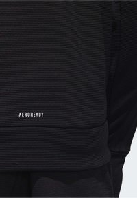 Svart texturerad sportig huvtröja med ribbat mönster och "AEROREADY"-logotypen i vitt på bröstet.