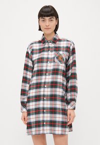 Abito a camicia a quadri in bianco, rosso, verde e grigio; presenta un frontale con bottoni, maniche lunghe e una tasca sul petto sinistro con un design ricamato.