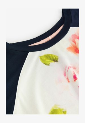 Top corto a maniche corte navy e bianco con stampa floreale in rosa e verde, con scollatura tonda e morbida texture del tessuto.