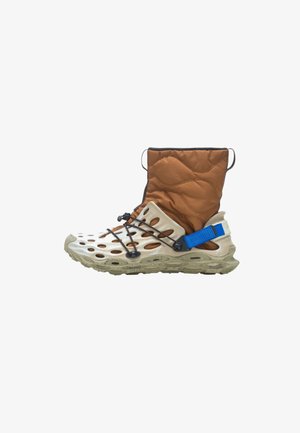 Hybrid-boot, jossa on beige kumipohja ja leikattu muotoilu. Ruskea tikattu kangasvarsi, mustat yksityiskohdat ja sininen säädettävä hihna. Karkea pohja.