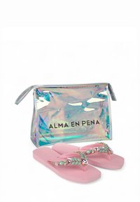 Roze teenslippers met juweelige accenten en een transparante holografische tas met zwarte tekst "ALMA EN PENA." Gladde textuur, lichtgewicht ontwerp.