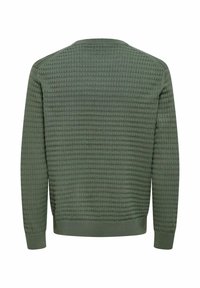 Pull vert texturé présentant un col rond côtelé, des manches longues et un motif gaufré sur tout le dos. Matière douce avec un ourlet ajusté.