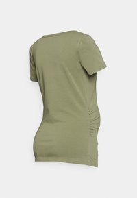 T-shirt de mangas curtas em verde-azeitona, feita de algodão suave, comDetalhes de franzido nas laterais. Gola redonda padrão com um corte descontraído.