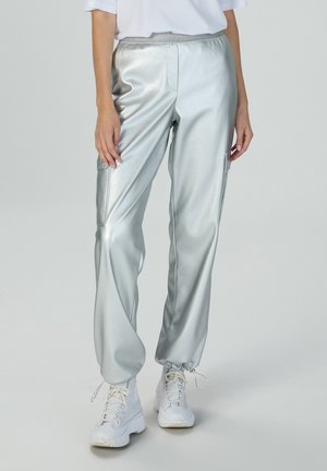 Metallisch silberne Jogginghose mit elastischem Bund, seitlichen Taschen und elastischen Bündchen. Sie zeichnet sich durch eine glatte, glänzende Textur und eine lockere Passform aus.