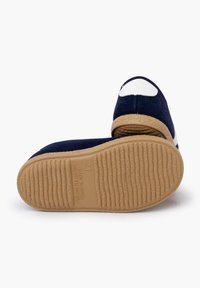 Navy blue slipper with a white accent, made of soft fabric. The textured rubber sole features horizontal ridges and embossed details.