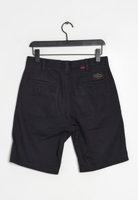 Tummansiniset puuvillahousut, joissa on suora leikkaus, kahdella takataskulla ja vyötäröllä etiketti. Pintakuvio on sileä eikä näkyviä kuvioita.