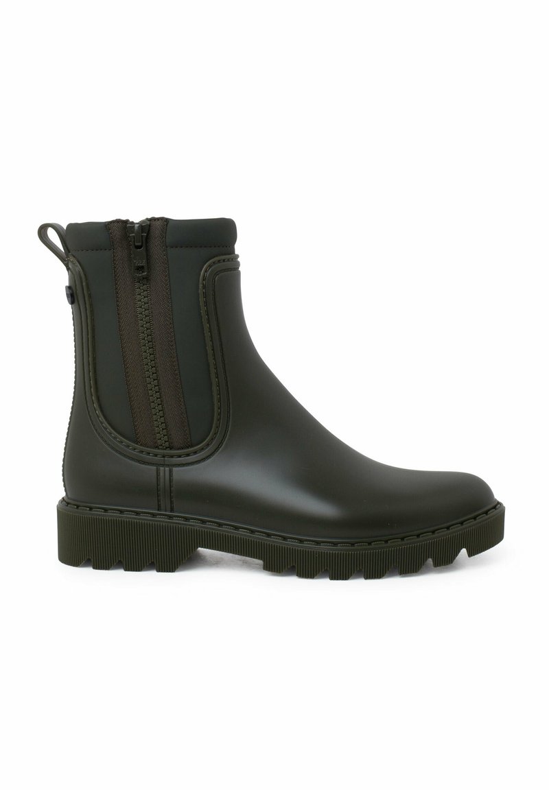 Bottes de cheville en caoutchouc vert avec des semelles à grip texturé et des zips sur les côtés. Fini lisse avec des coutures en relief le long des bords.
