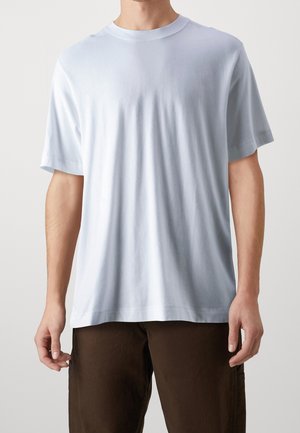 Hellblaues Baumwoll-T-Shirt mit Rundhalsausschnitt und kurzen Ärmeln. Glatte Textur, lockerer Schnitt und keine sichtbaren Muster oder Akzente.