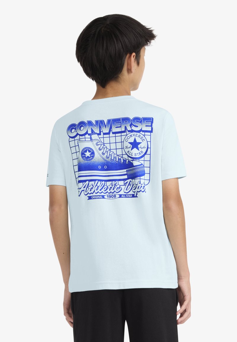 Ανοιχτό μπλε μπλουζάκι με μεγάλο μπλε γραφικό ενός παπουτσιού Converse και το κείμενο «Athletic Dept» στην πλάτη, κοντά μανίκια, βαμβακερό υλικό.