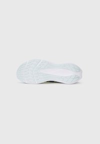 Semelle de chaussure en caoutchouc blanc texturé avec un motif de bande de roulement pour une meilleure adhérence, bords légèrement surélevés et conception flexible.