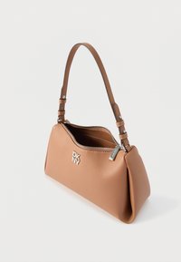 Pruuninahast õlakott ümarate vormidega, hõbedase luku ja logodetailiga. Omab ühte reguleeritavat rihma kandmiseks.