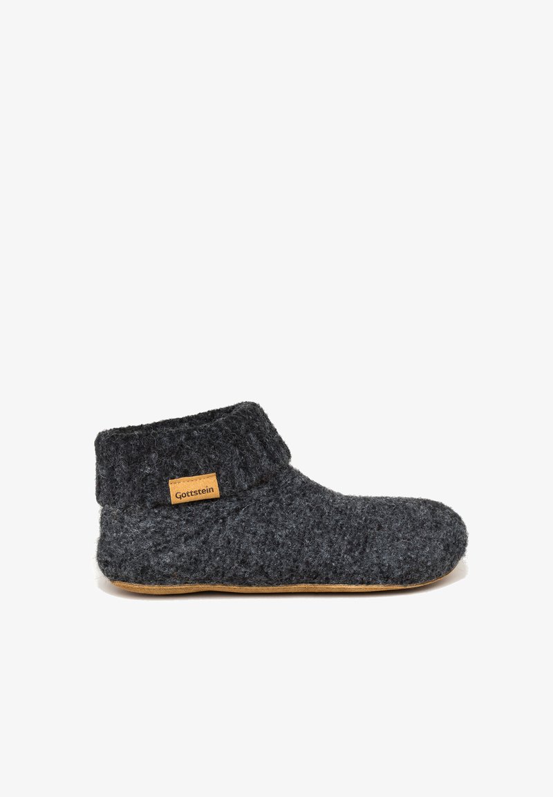 Grijze wollen slipper met een hoge enkelontwerp, met een textielstructuur en een bruin label met "Gottstein" aan de zijkant. Platte zool.