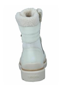 Weiße Leder-Stiefeletten mit einem weichen Pelzfutter, ausgestattet mit zwei Riemen und einem Reißverschluss. Die Sohle ist strukturiert und hat einen leichten Absatz.
