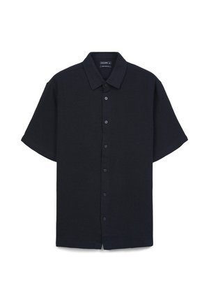 Chemise à manches courtes à boutons, de couleur bleu marine foncé, avec col, boutons sur le devant et un tissu texturé avec une coupe décontractée.