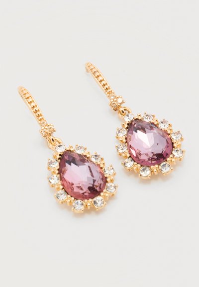 Χρυσά σκουλαρίκια σταγόνα με μεγάλα δάκρυα σε σχήμα σταγόνας με μοβ πέτρες, περιτριγυρισμένα από μικρότερες διαυγείς κρυστάλλους σε απλό λευκό φόντο.