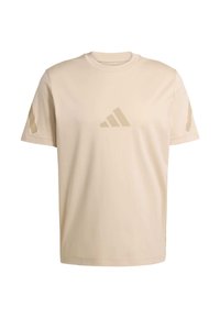 Camiseta de algodón beige con mangas cortas, cuello redondo y un sutil logo tonal en el pecho. Presenta detalles laterales texturizados.