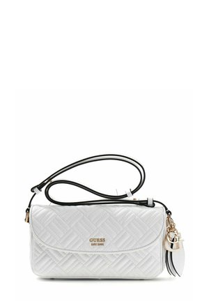 Sac bandoulière matelassé blanc de Guess avec bordure noire, logo doré, et breloque porte-clés dorée et blanche attachée à la sangle.