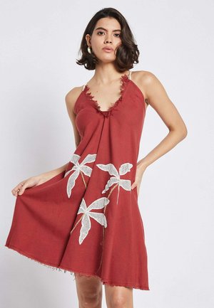 Rotes Kleid mit tiefem V-Ausschnitt und Fransenbesatz. Es verfügt über weiße florale Stickerei mit Textur. A-Linien-Form, knielang. Verstellbare Träger.