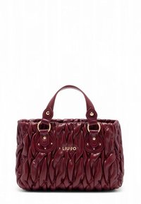 Bordeauxfarbene Handtasche aus gestepptem Kunstleder mit goldfarbenen Beschlägen, mit doppelten Griffen und rundlicher Form. Markenlogo sichtbar.