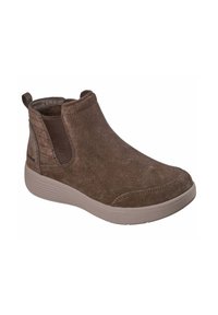 Stivale alla caviglia in suede marrone con pannelli laterali elasticizzati, punta rotonda e suola in gomma testurizzata. Presenta dettagli cuciti e una linguetta per indossarlo.
