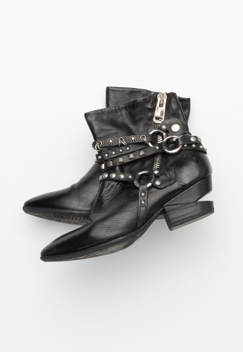 Svarta läderankelstövlar med spetsiga tår, prydda med silvernitar och remmar. Har en sidogdragkedja och en låg blockklack.