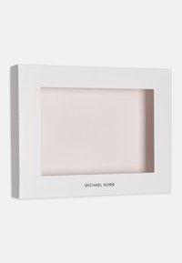 Biała ramka na zdjęcia z przezroczystym szklanym przodem i gładkim wykończeniem. Na dolnej krawędzi znajduje się logo "MICHAEL KORS". Prosty, prostokątny design.
