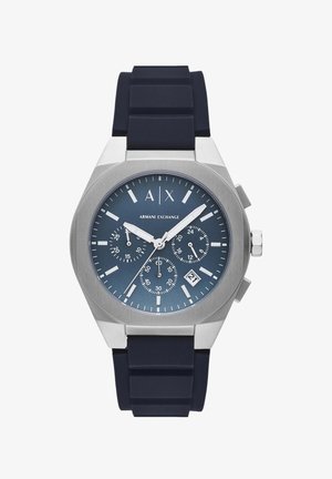 Stříbrné nerezové hodinky s námořnickým modrým silikonovým páskem, kulatým ciferníkem, třemi subciferníky, bílými ukazateli a zobrazením data.