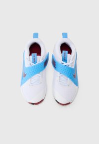 Nike basketball shoes featuring a white mesh upper with a blue strap, red accents, and a textured overlay. Flat rubber sole with color details.