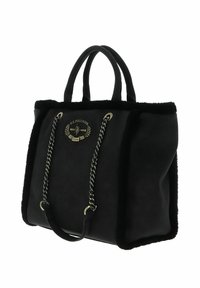 Sac cabas noir avec bordure en fausse fourrure, accents en chaîne et patch logo. Matière douce, forme structurée et doubles poignées pour un transport facile.
