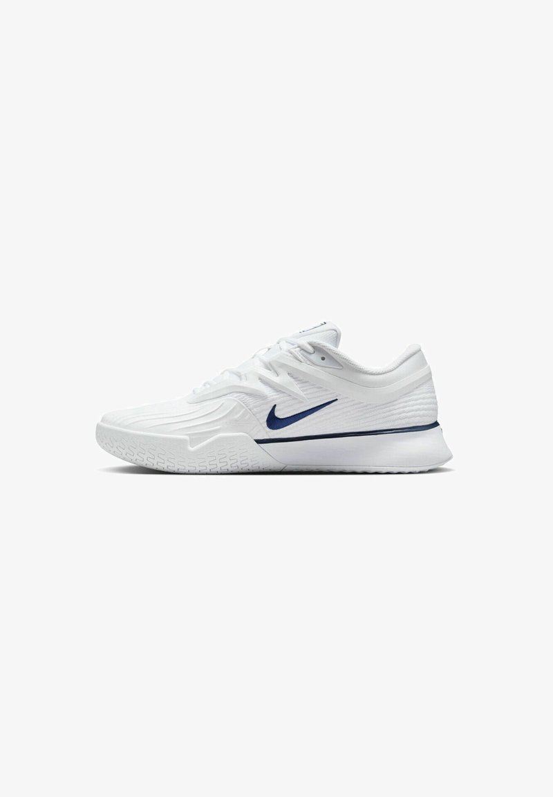 Baskets de sport blanches avec une tige en textile texturé et un accent bleu marine sur le côté. Elles possèdent une semelle en caoutchouc avec une semelle à motif.