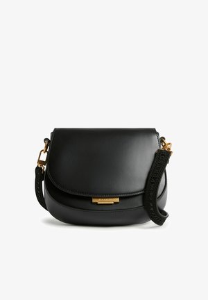 Borsa da sella in pelle nera con patta curva, ferrature dorate e tracolla nera staccabile con dettagli testurizzati.