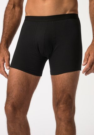 Boxer-briefs noirs en tissu doux, avec un design uni, une taille élastique et une coupe ajustée pour le confort et le soutien.