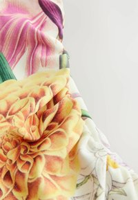 Tessuto con motivo floreale che presenta calendule gialle e arancioni, gigli viola e foglie verdi su uno sfondo chiaro; superficie texturizzata.