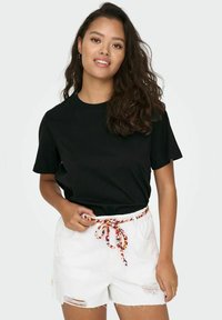 Black cotton t-shirt with short sleeves, paired with white denim shorts featuring a colorful braided drawstring and distressed details.