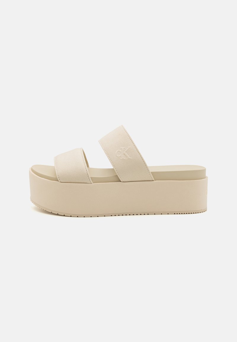 Sandali platform beige con due ampie cinghie, realizzati in tessuto, con suola texturizzata e dettagli logo sottili. Design liscia e minimalista.