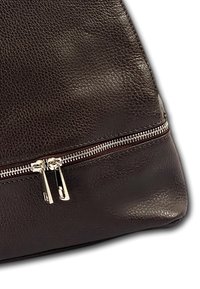 Sac à main en cuir noir avec une surface texturée, doté d'un zip argenté et d'une forme structurée. Aucun logo ni motif visible.