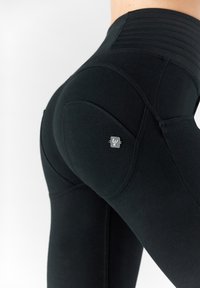 Leggings neri a vita alta con una fascia testurizzata, forma aderente e una tasca laterale con dettaglio del logo metallico.