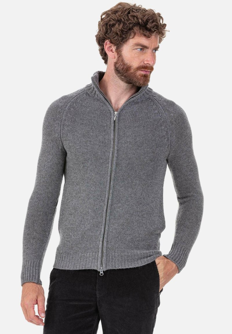 Pull gris à fermeture éclair avec une texture côtelée, une coupe ajustée et un col haut avec des accents en tricot torsadé sur les épaules.